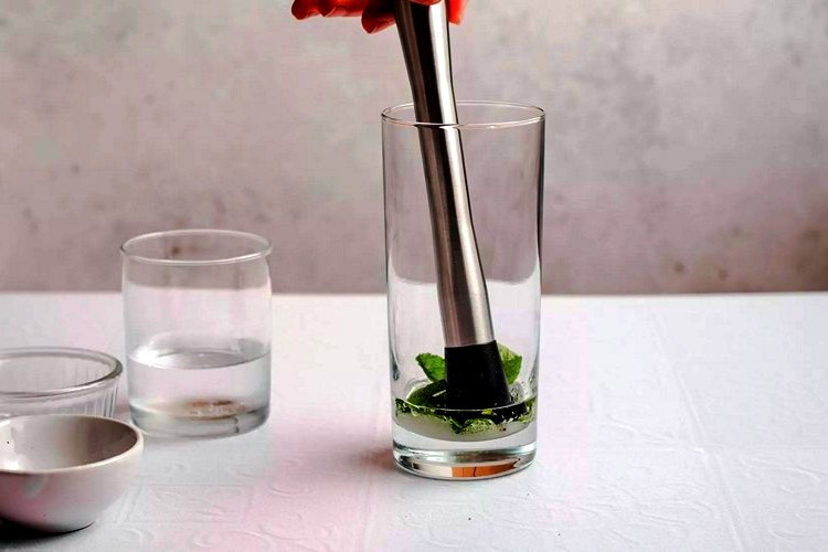 У склянку для коктейлю кладуть цукор, листя м'яти та трохи содову.